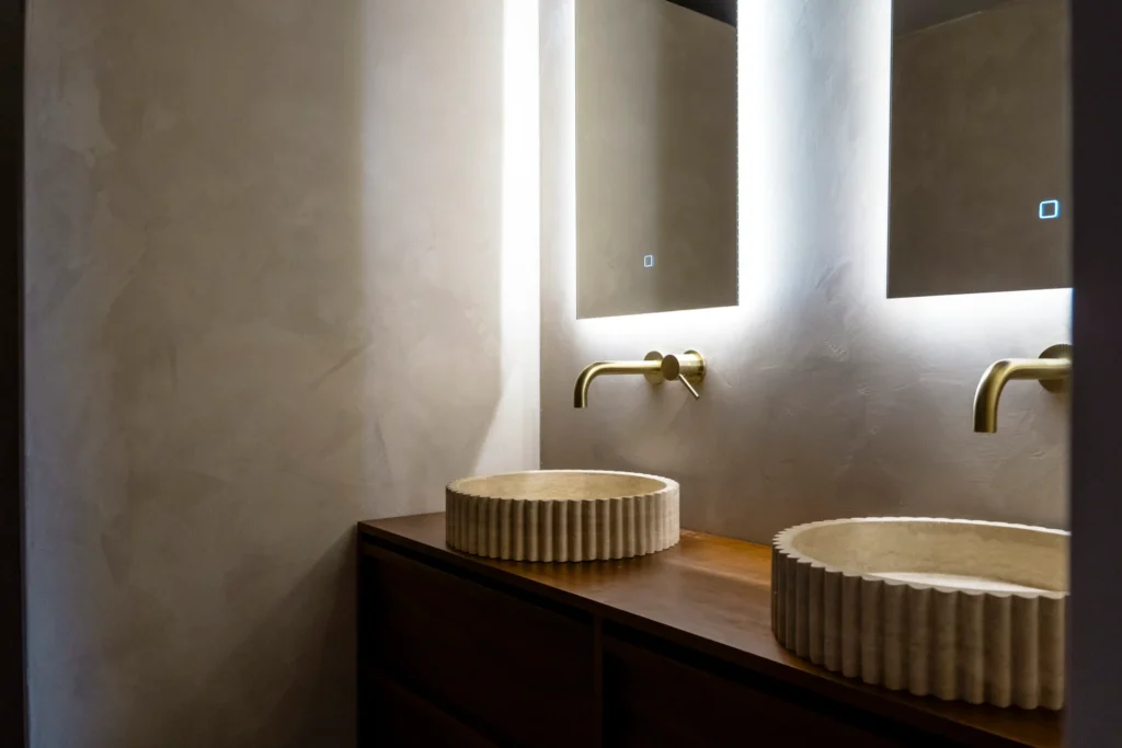Badkamer met twee ronde waskommen en spiegelverlichting bij Project Beek